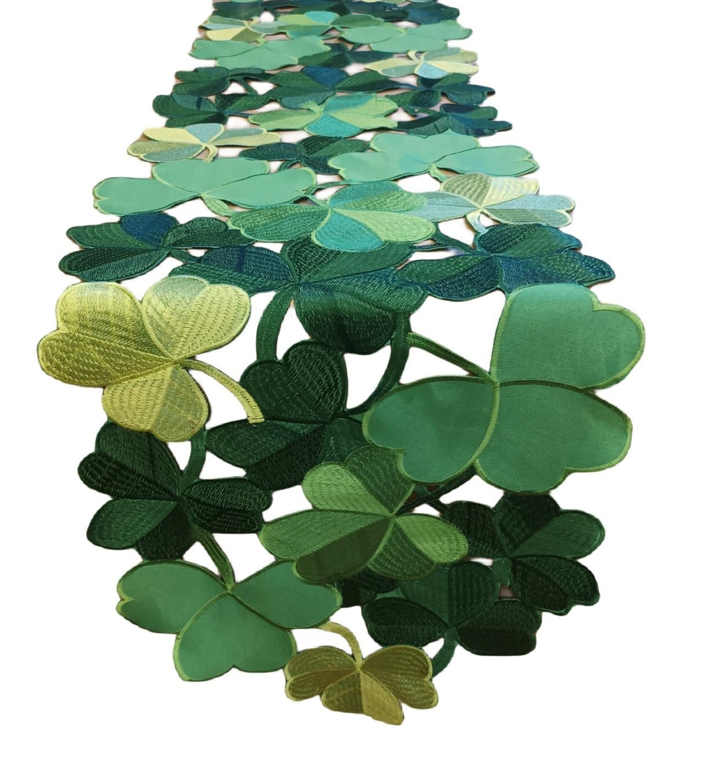 Green embroidered clover cutouts table runner on a white background, close-up view