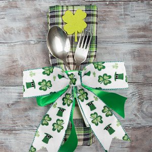 St. Patrick's Day cutlery holder with shamrocks and hats, tied with a green bow.