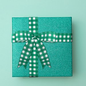 Sparkly teal gift box with green and white gingham ribbon tied in a bow.