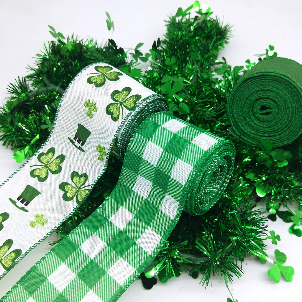 Two rolls of St. Patrick's Day ribbon, one with shamrocks and hats, the other with green plaid, surrounded by green tinsel and shamrock confetti.