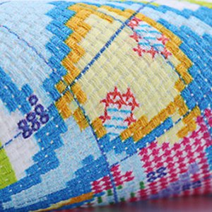 Close-up of stamped cross stitch fabric with colorful geometric pattern and embroidered details.