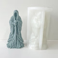 Silicone mold and a gray resin cast of a hooded figure holding a sword, displayed on a white background.