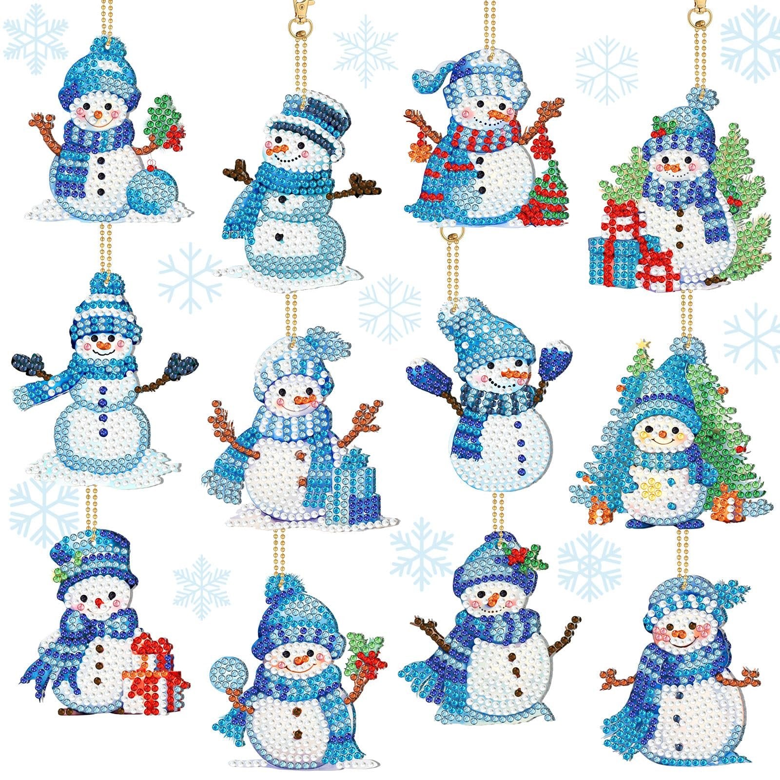 Twelve diamond art snowman keychain ornaments with blue winter hats and scarves, some holding gifts or trees.