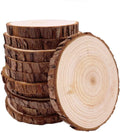 Stack of unfinished natural pine wood slices with bark, one slice in foreground showing wood grain