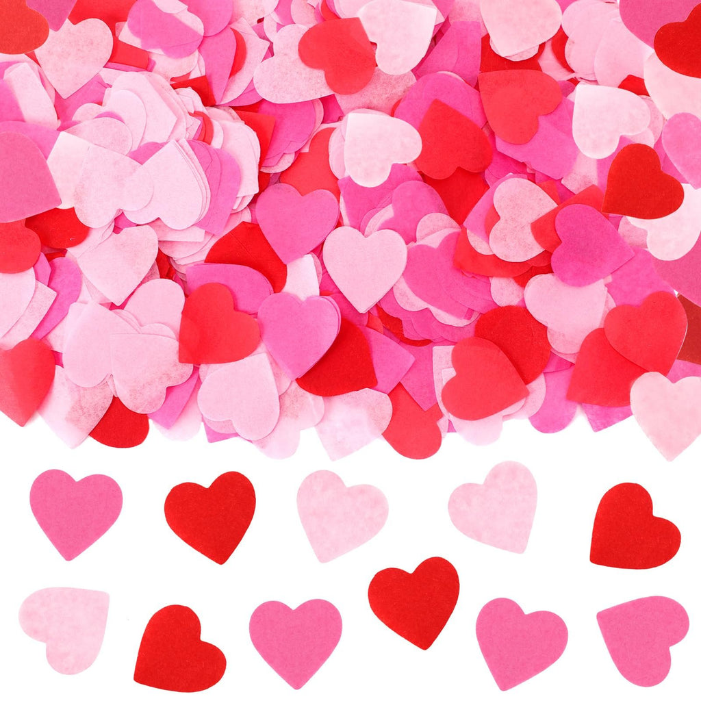 Scattered red, rose, and pink heart-shaped paper confetti on a white background, with a neat row of hearts at the bottom.