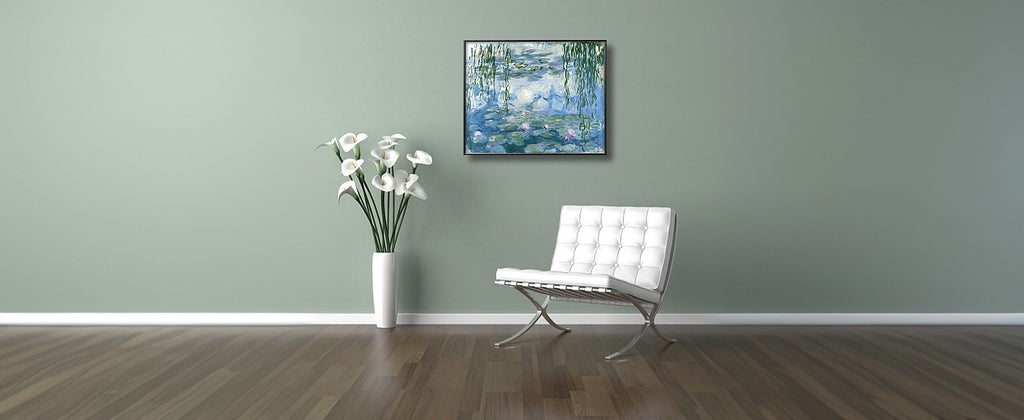 Framed Monet Water Lilies painting hanging on a wall above a white chair and vase of flowers