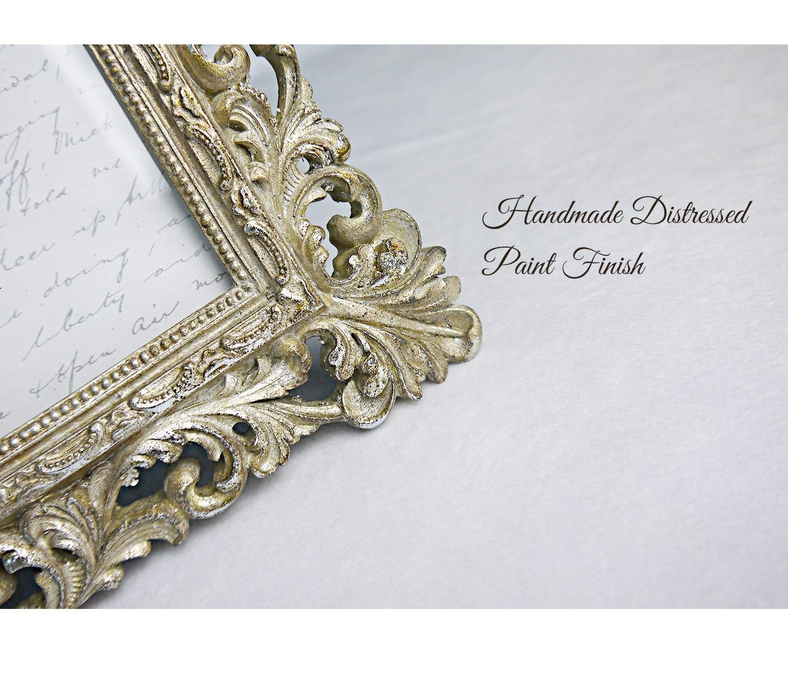Ornate vintage gold picture frame with distressed paint finish, shown at an angle on a white surface.