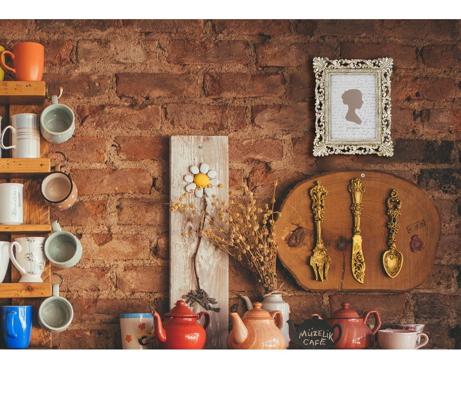 Ornate antique gold picture frame with silhouette art hanging on a brick wall above teapots and mugs.