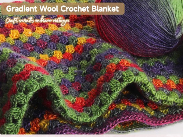 Crocheted blanket with a ball of gradient ombre wool yarn in purple, green, and red hues.