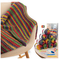 Crocheted blanket draped over a chair next to a display of yarn skeins and crochet tools.