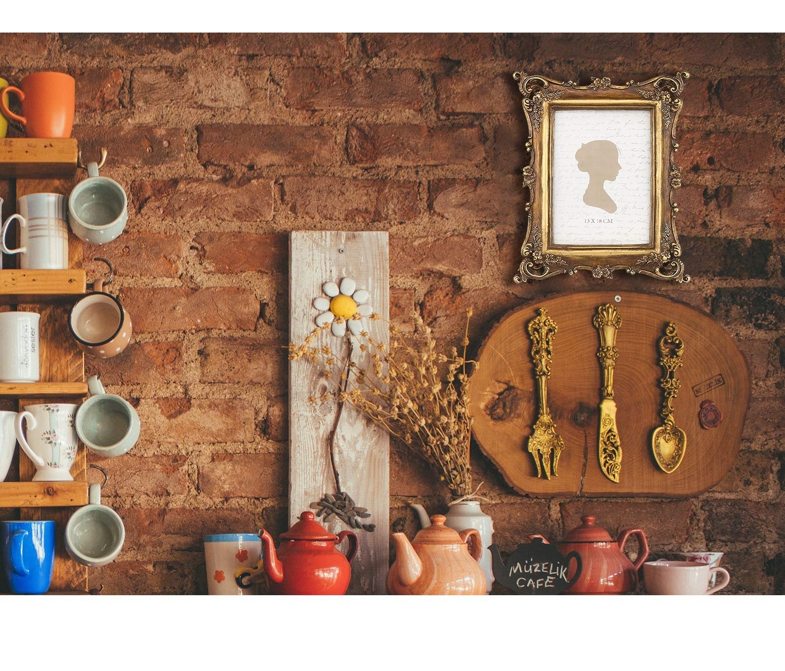 Vintage-style ornate gold picture frame displaying a silhouette on a brick wall shelf with mugs and teapots.