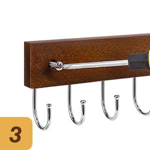Close-up of a brown wooden key hook rack with 12 metal hooks, showing a screwdriver being used to install it.
