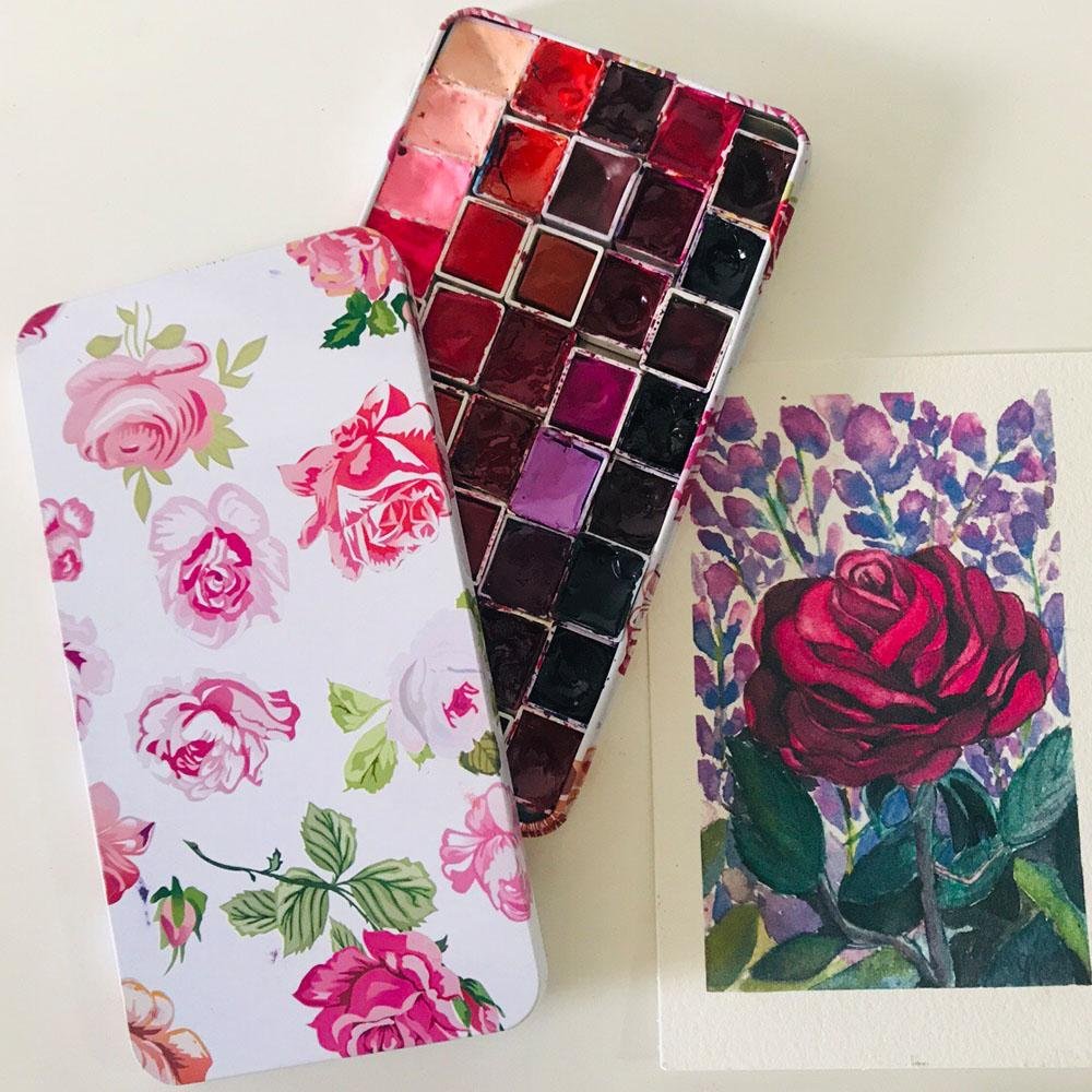 Watercolor paint tin box with 20 full pans of paint and a floral painting of a red rose
