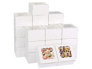 Stack of white bakery boxes with clear windows, two boxes in front show cookies and pretzels inside