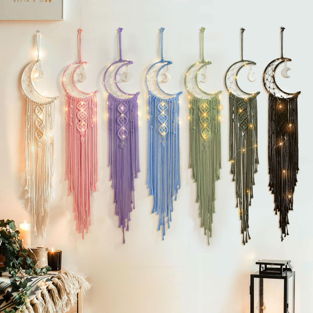 Collection of macrame crescent moon dream catchers with string lights hanging on a wall in various colors