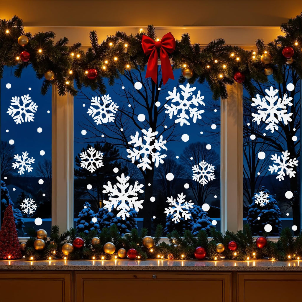 Christmas window decorated with white snowflake clings, garland, lights, and ornaments