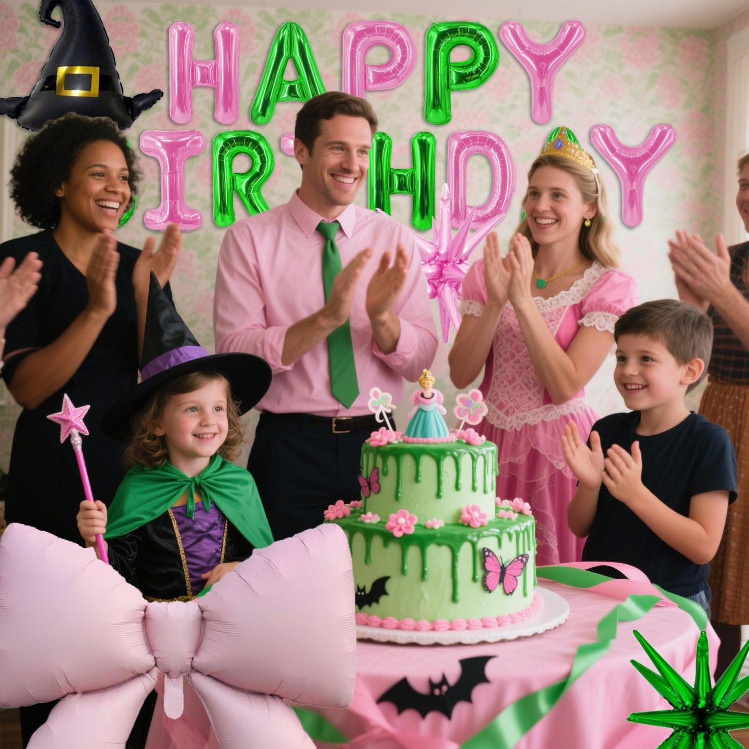 Family celebrating a birthday with a green cake, balloons, and a witch hat.
