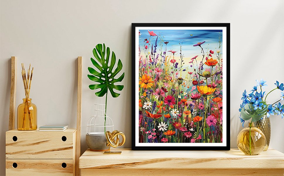 Framed painting of a vibrant field of wildflowers under a blue sky, displayed on a shelf with decorative vases and plants.