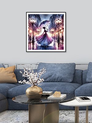Diamond painting of a woman with an umbrella walking down a street at night, framed and hanging on a wall above a sofa.