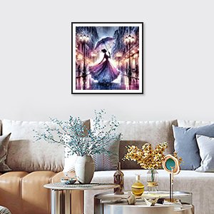 Diamond painting kit of a woman with an umbrella walking down a city street at night, framed and hanging on a wall above a sofa.