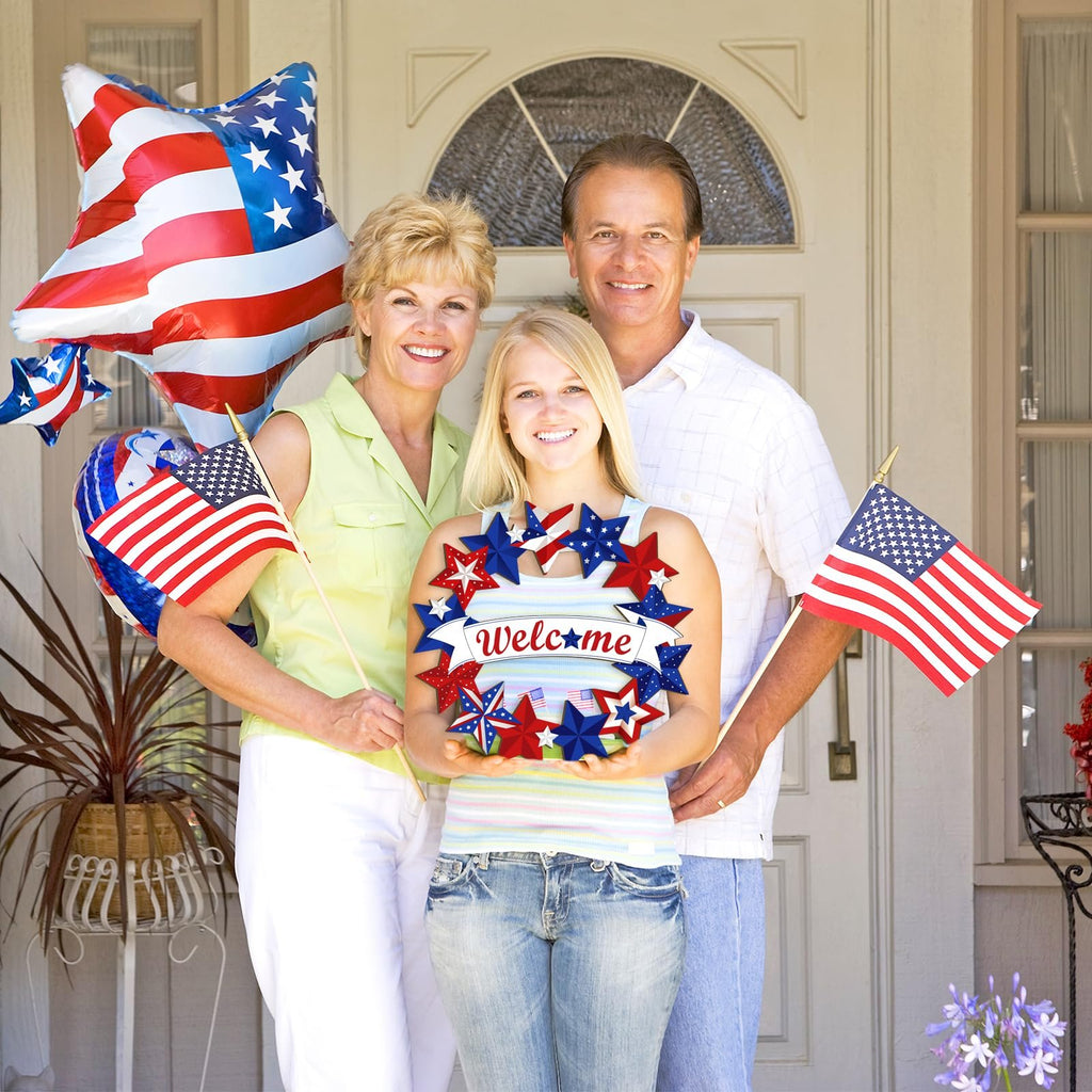 Family holding a patriotic star wreath with 'Welcome' text and American flags, standing in front of a door.