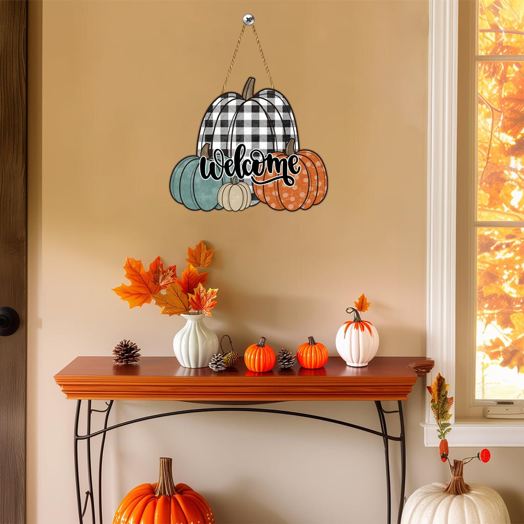 Wooden pumpkin welcome sign with buffalo plaid and polka dot patterns hanging on a wall above a console table with fall decor.